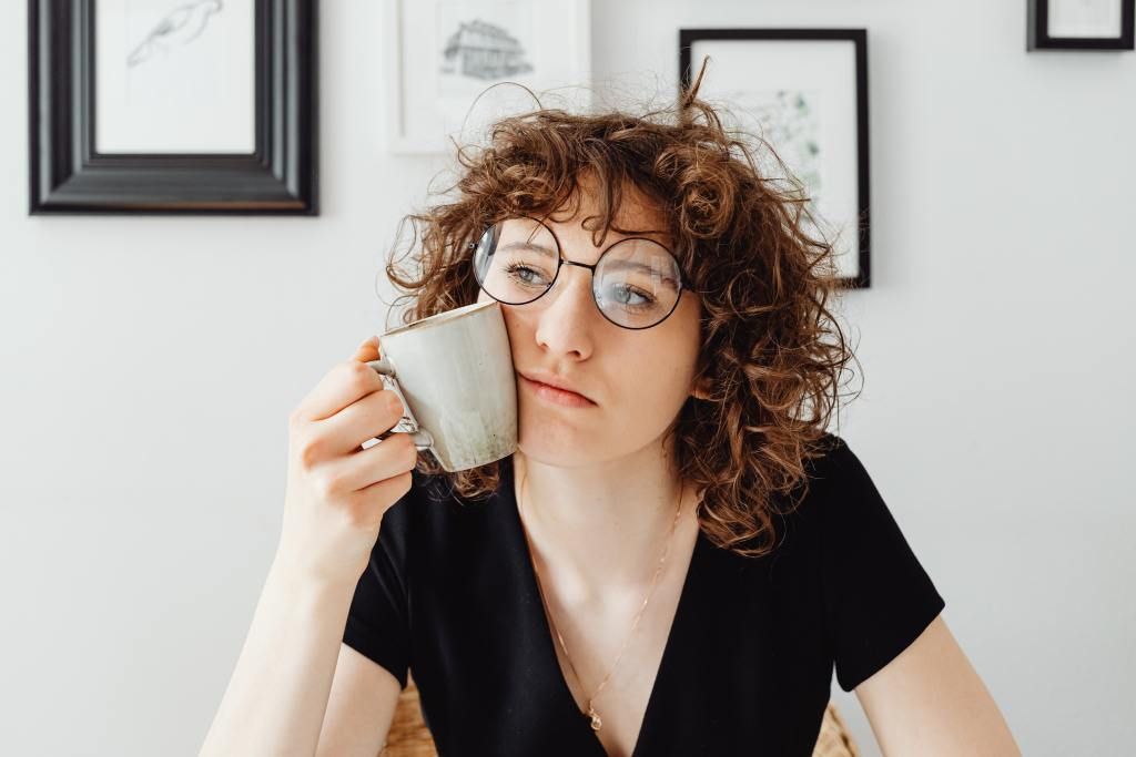 Woman with coffee mug wondering if a surrogacy situation is too good to be true.