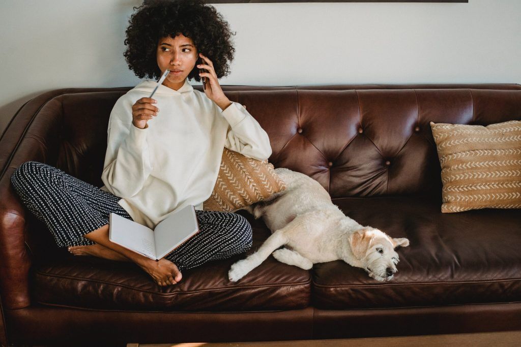 woman sitting on couch with dog and not
