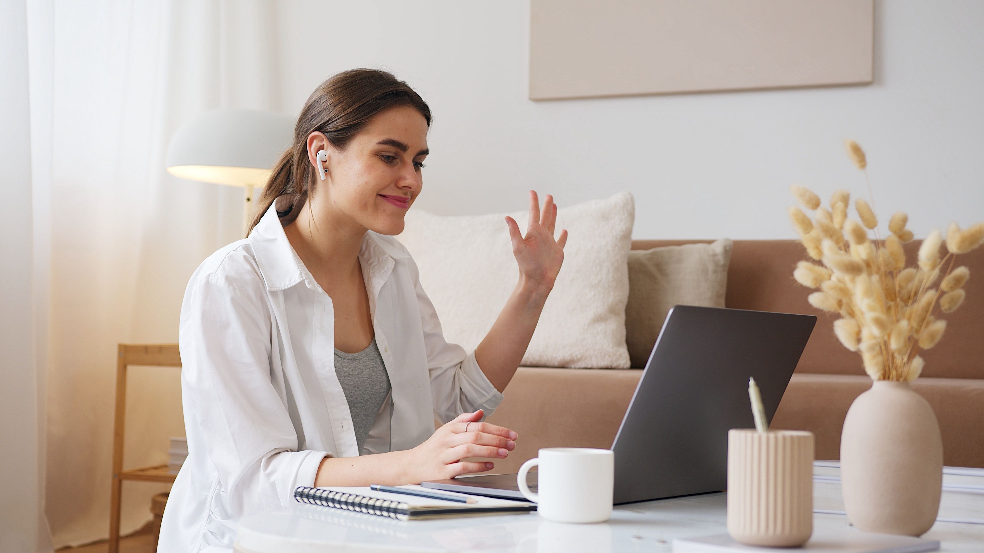 woman saying hi to a friend on a laptop